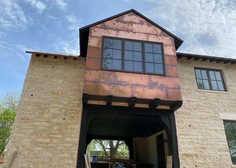 Copper metal panel facade on a stone building for Roof Repair in Catalina